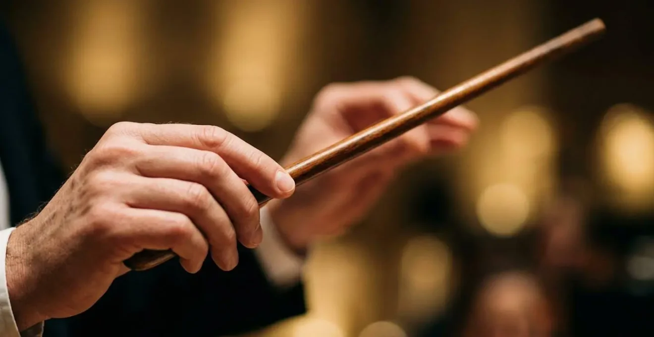 Détail macro des mains d'un chef d'orchestre tenant une baguette avec profondeur de champ réduite