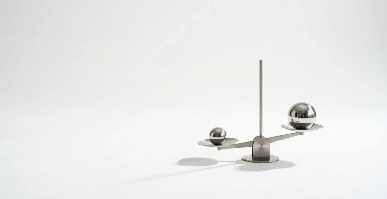 Balance minimaliste en équilibre précaire avec deux sphères métalliques de tailles légèrement différentes sur fond épuré